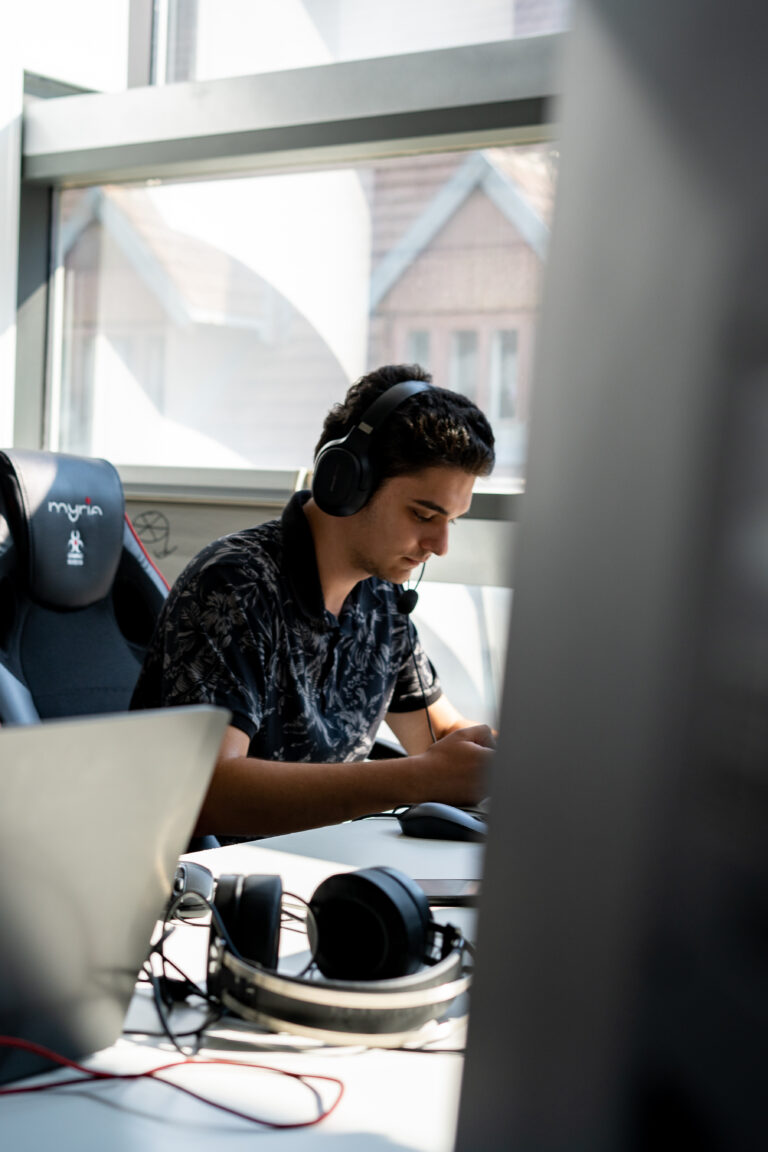 Pixel Bowl team member using a headset at a workstation